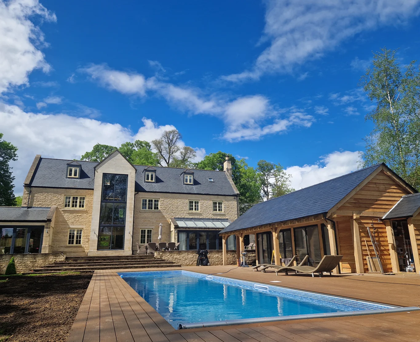 Newly constructed outdoor swimming pool integrated with garden landscaping