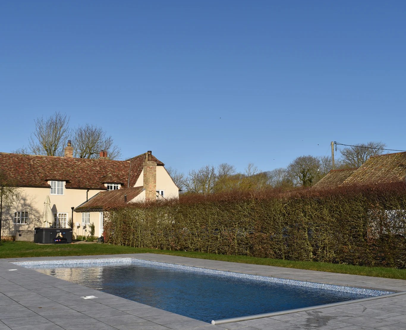 Rectangular outdoor swimming pool set within a lawned garden